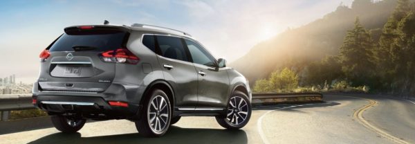2019 Nissan Rogue in silver parked along a scenic highway.